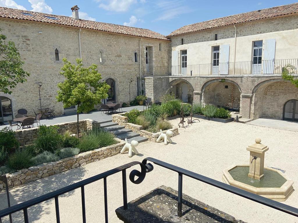 een binnenplaats met twee witte standbeelden voor een gebouw bij Domaine de la Bedosse in Alès