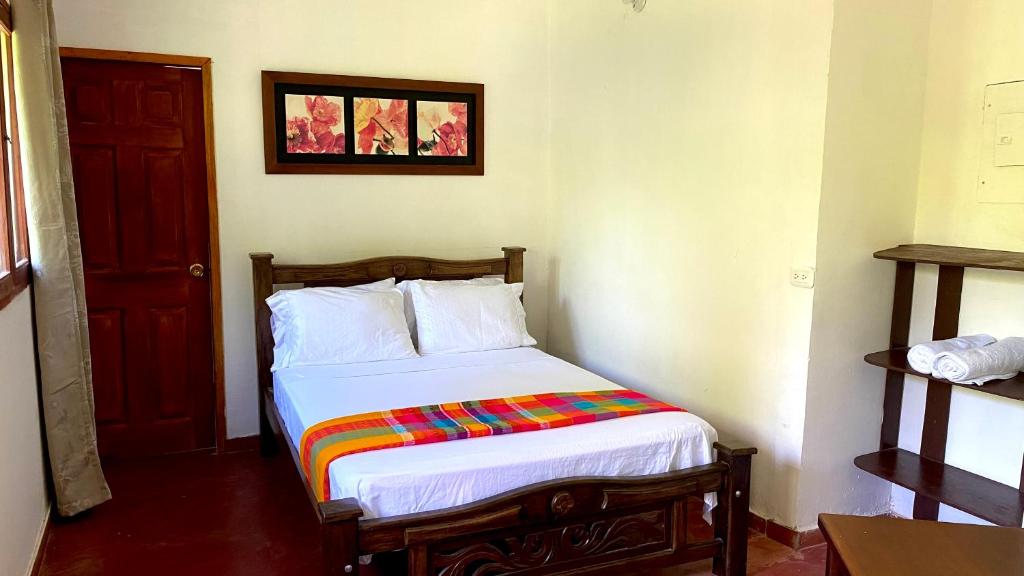 a bedroom with a bed with a colorful blanket on it at Minca Santa Marta Casa Scalea in Minca
