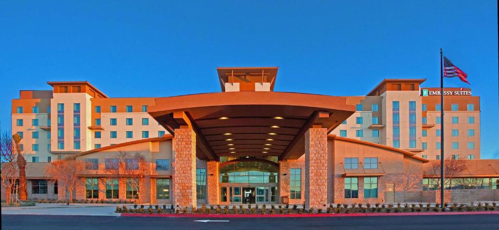 a building with a large building with a flag on it at Embassy Suites Palmdale in Palmdale