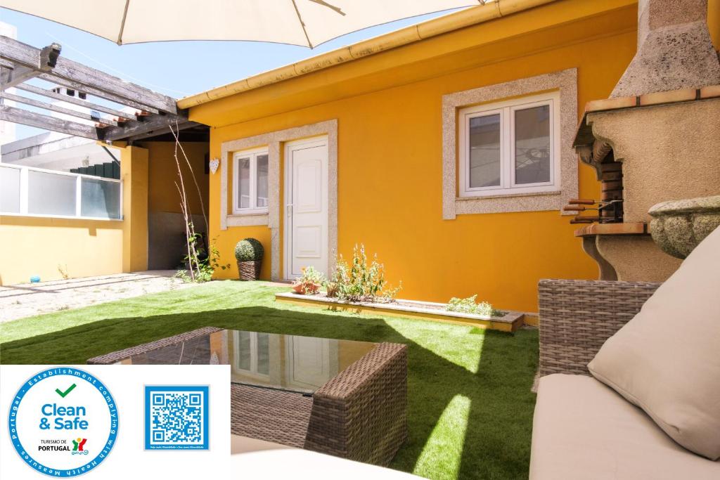 Perafita Yellow House - EcoHostPT في Perafita: منزل فيه حديقة و لوحة مكتوب عليها احلا و امان