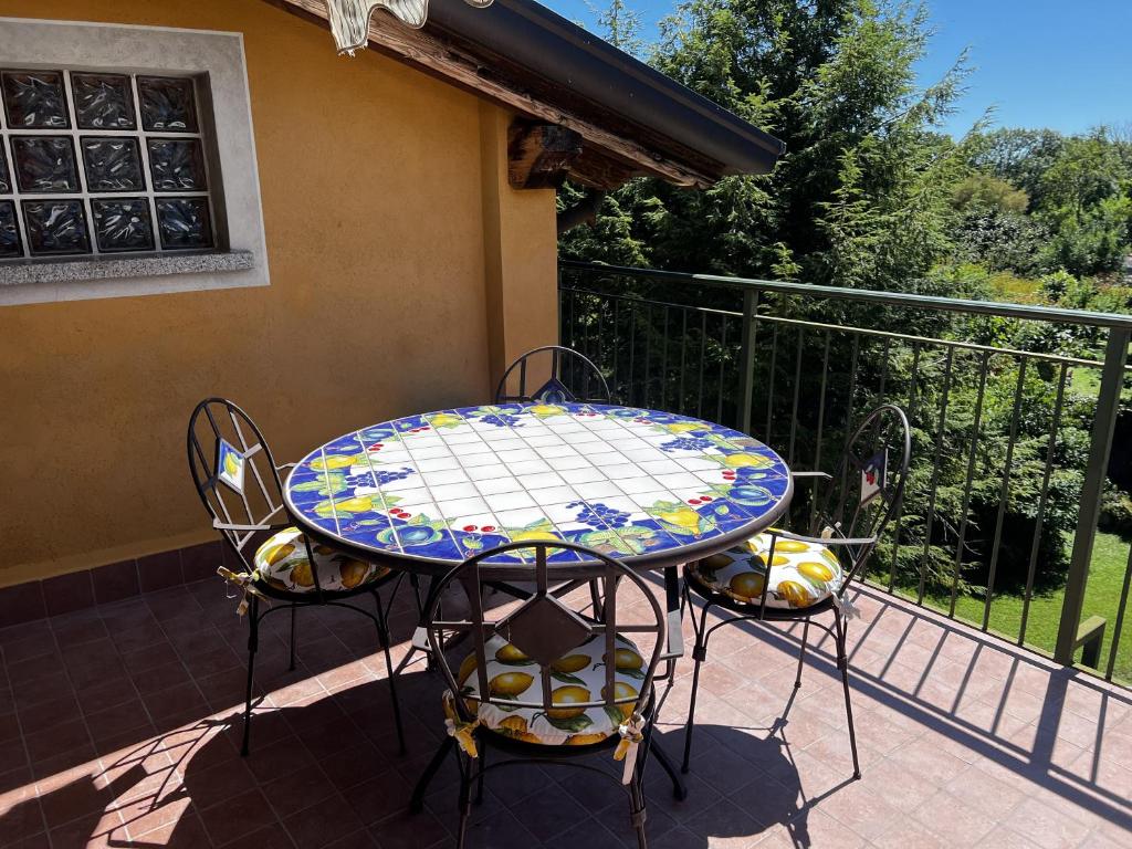 uma mesa de pátio e cadeiras numa varanda em Il nido di Arianna em Leggiuno