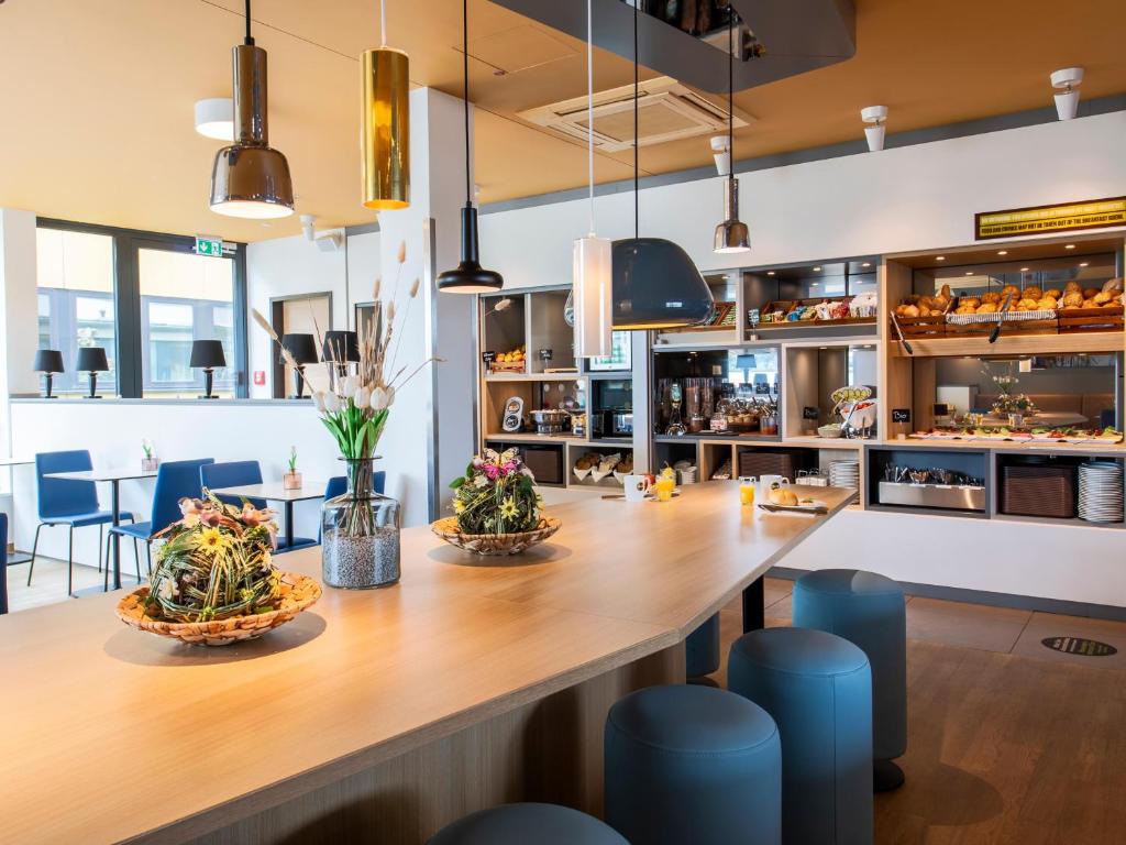 een restaurant met een grote houten tafel met planten erop bij B&B Hotel Landshut in Landshut