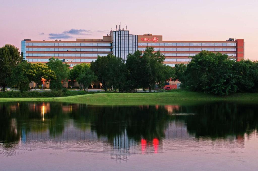 a large building with a reflection in the water at Hilton Orlando/Altamonte Springs in Orlando