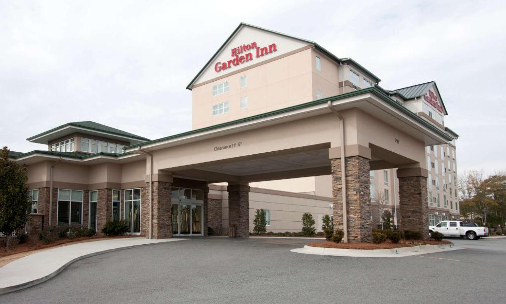 a front view of a hotel with a parking lot at Hilton Garden Inn Valdosta in Valdosta