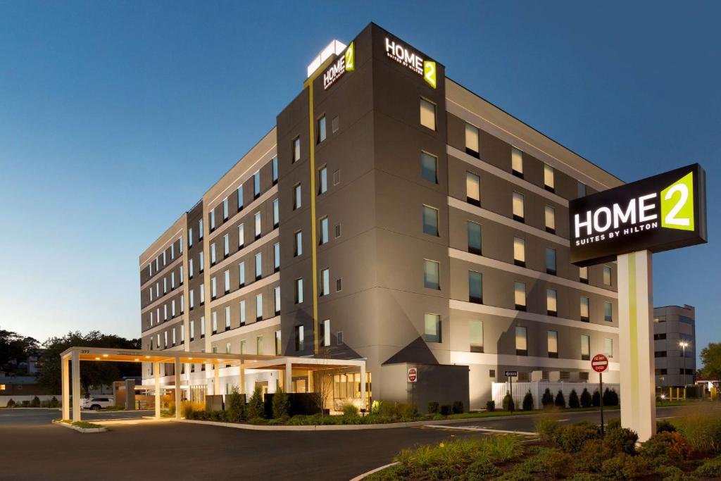 a hotel building with a sign in front of it at Home2 Suites By Hilton Hasbrouck Heights in Hasbrouck Heights