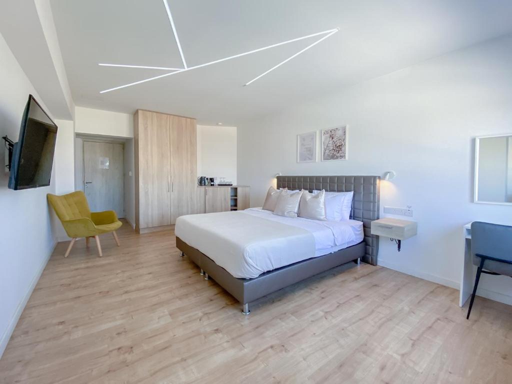 um quarto com uma cama, uma secretária e uma televisão em Phaedrus Living: Plateia Suite Brillante em Nicósia