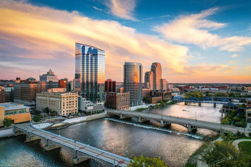 a city skyline with a bridge over a river at Amway Grand Plaza Hotel, Curio Collection by Hilton in Grand Rapids