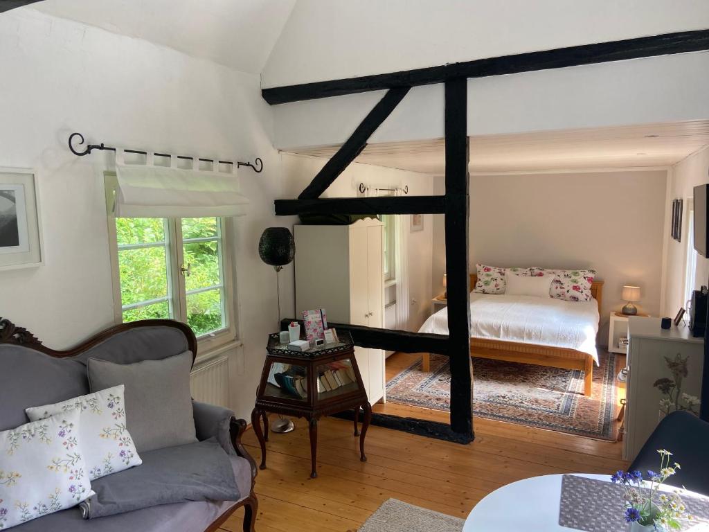 - un salon avec un lit et un canapé dans l'établissement Bergisches Cottage Solingen, à Solingen