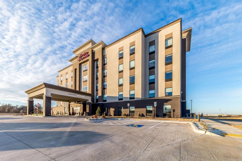 un gran edificio con un estacionamiento delante de él en Hampton Inn & Suites Pryor, Ok, en Pryor