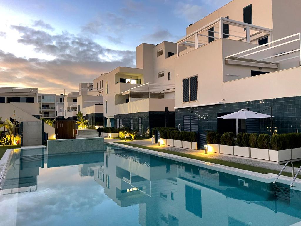 eine Villa mit einem Pool vor einem Gebäude in der Unterkunft Luxury Apartment Turquesa Del Mar in Alicante
