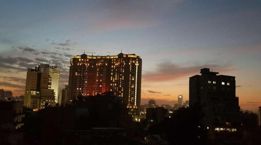 een skyline van de stad bij zonsondergang met hoge gebouwen bij ElSultan Hotel in Caïro