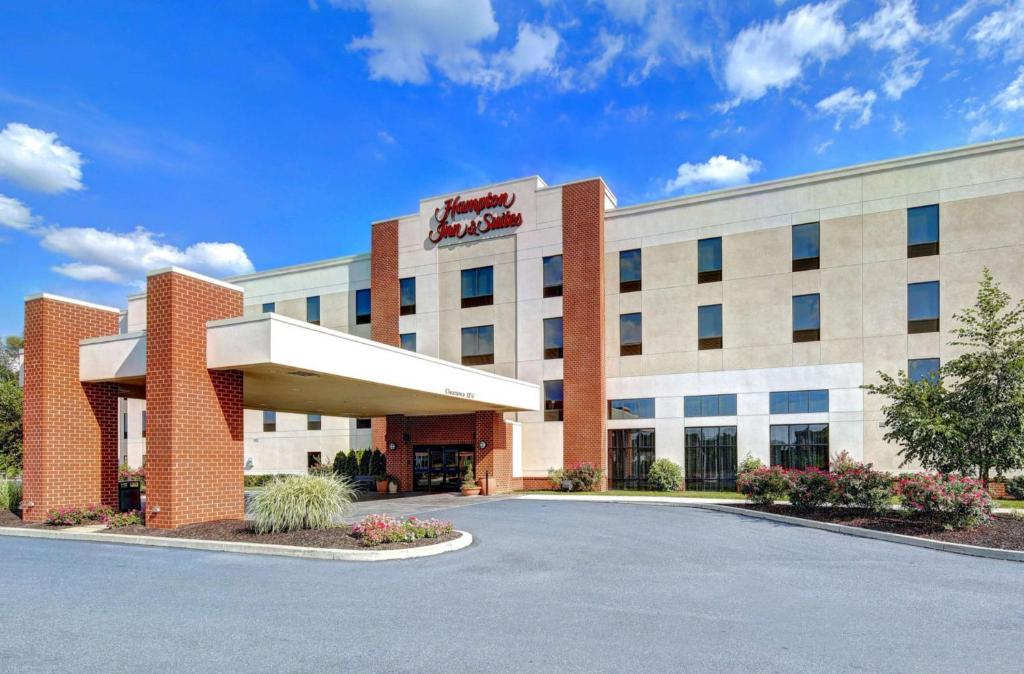 a hotel building with a sign on the front of it at Hampton Inn & Suites Harrisburg in Harrisburg