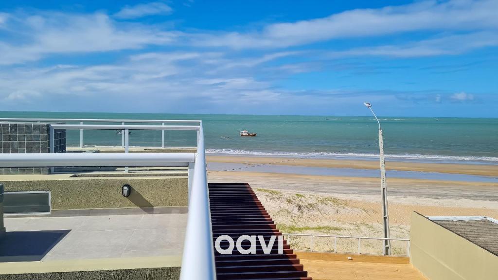 Qavi - Flat em Pirangi Living #PirangiChalé13 في بارناميريم: اطلالة على شاطئ مع قارب في الماء