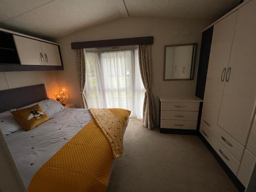 a bedroom with a large bed and a window at Honeycomb Lodge in Dollar