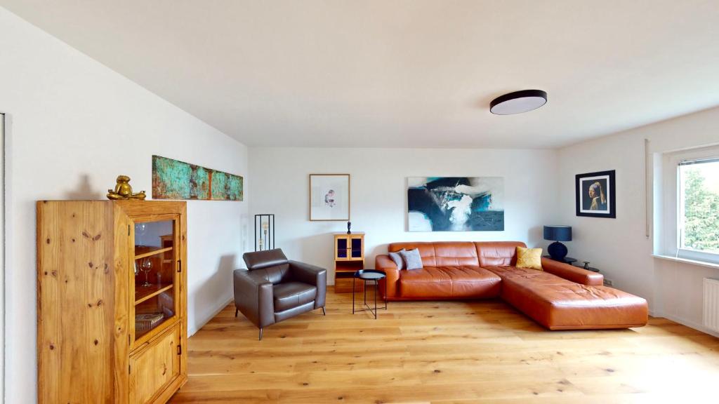 uma sala de estar com um sofá e uma cadeira em Schöne Ferienwohnung mit guter Anbindung, sehr guter Ausstattung und kostenloses WLAN em Herten