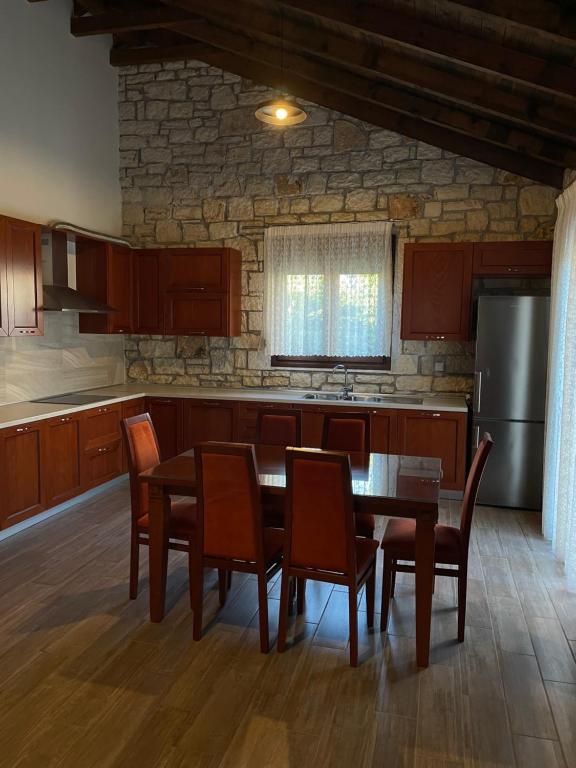 a kitchen with a table and chairs and a refrigerator at Villa Maria 2 in Gliki