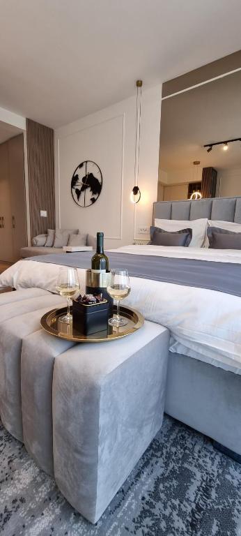 a bedroom with a large bed and a table with wine glasses at Beograd na vodi - BW Terra Exclusive in Belgrade