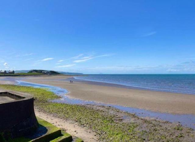 uma praia com o oceano e uma pessoa andando sobre ele em Prestwick Pink Pad em Prestwick