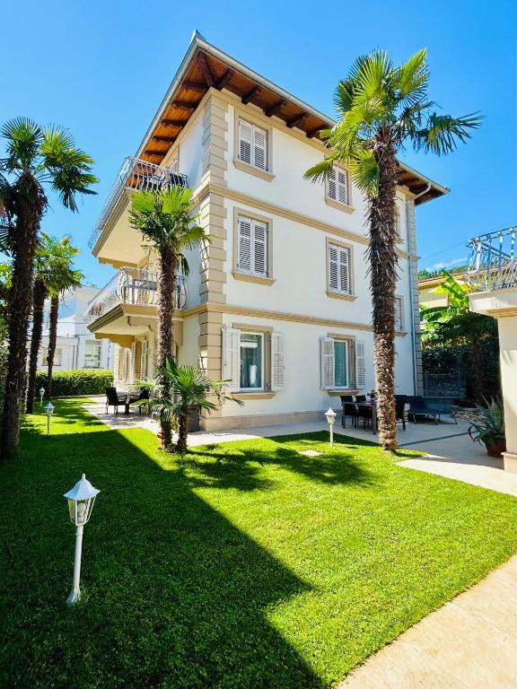 a large house with palm trees in the yard at VILLA GIANNI - lux. apt. ROMA -5* in Lovran