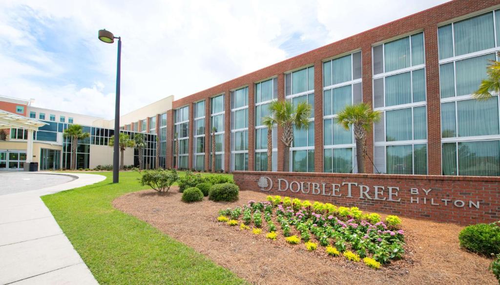 un edificio con una señal que lee la institución de docenas de árboles en DoubleTree Hotel & Suites Charleston Airport, en Charleston