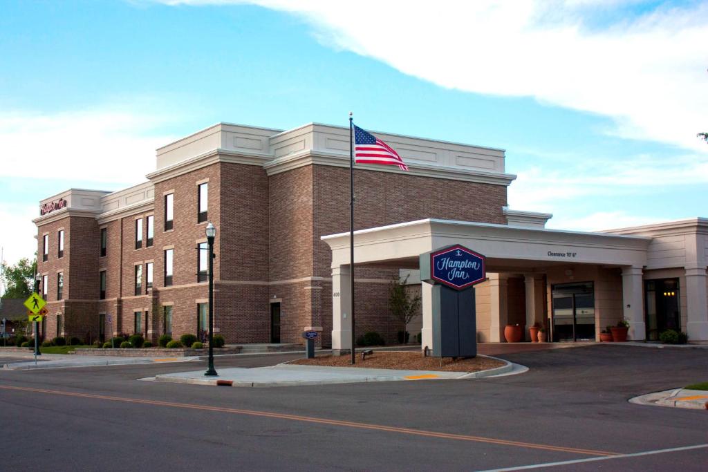 un edificio con una bandera americana delante de él en Hampton Inn - Burlington, en Burlington