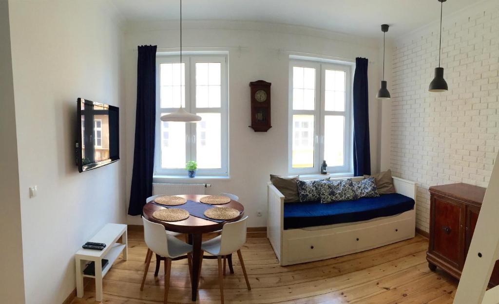a living room with a table and a bed and a table and chairs at Apartment Sopot I in Sopot