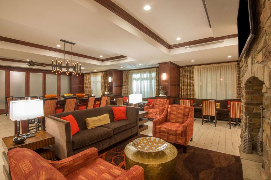 a living room with a couch and chairs and a bar at Hampton Inn Kingston in Kingston