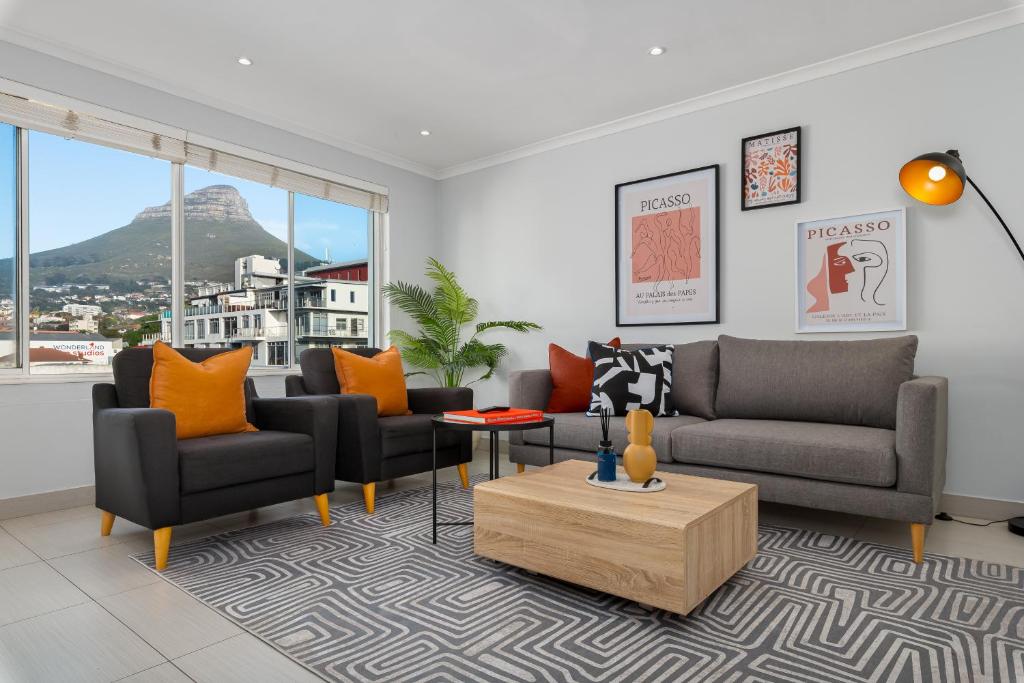 a living room with a couch and chairs and a table at 220 On Loop Luxury Apartments in Cape Town
