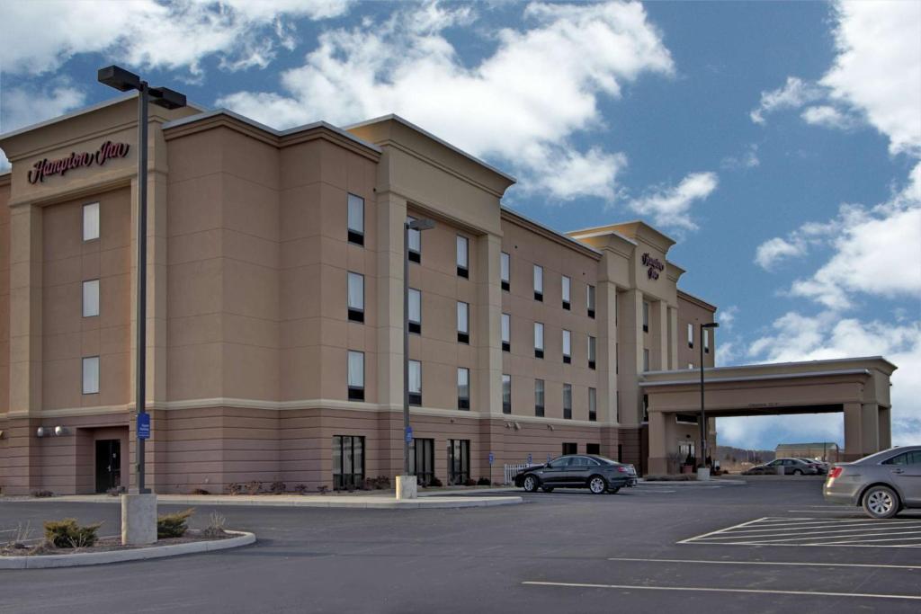 a large building with cars parked in a parking lot at Hampton Inn Defiance in Defiance