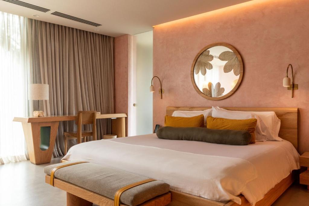 1 dormitorio con 1 cama grande y espejo en 23 Hotel Medellin, en Medellín