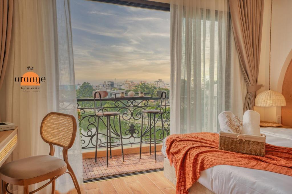 1 dormitorio con balcón con cama y ventana grande en iRest Orange Tay Ho Lakeside Apartment en Hanoi