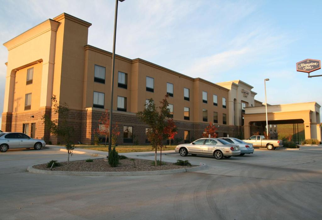 a building with cars parked in a parking lot at Hampton Inn Clinton in Clinton