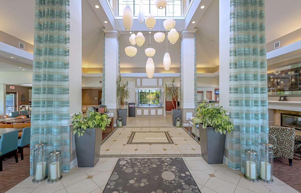 a lobby of a hotel with columns and plants at Hilton Garden Inn Plymouth in Plymouth