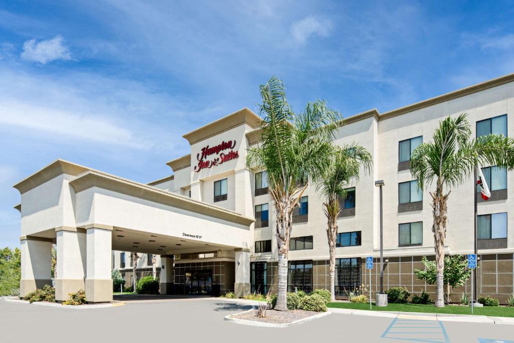 ein Hotel mit Palmen davor in der Unterkunft Hampton Inn and Suites Bakersfield / Highway 58 in Bakersfield