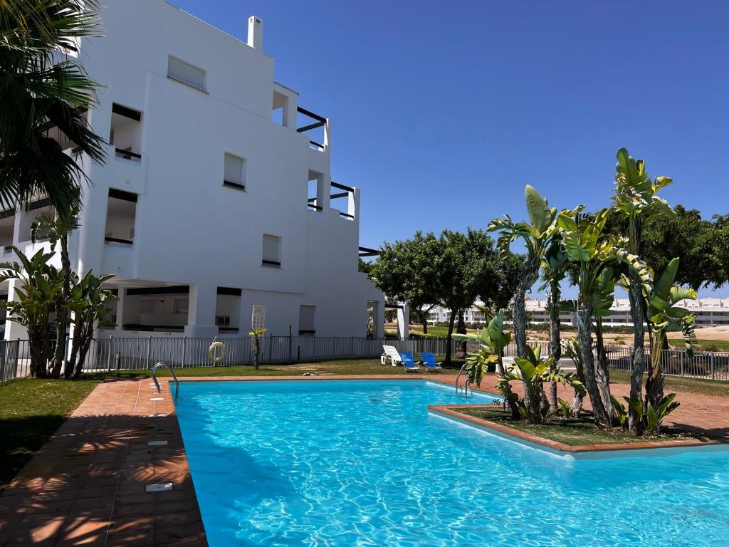 une piscine en face d'un bâtiment dans l'établissement Las Terrazas De La Torre Golf Resort, à Las Pedreñas