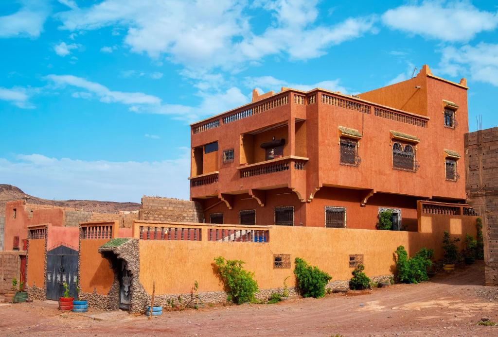 an orange brick building with a balcony on top at Dar Fadma in Ouarzazate