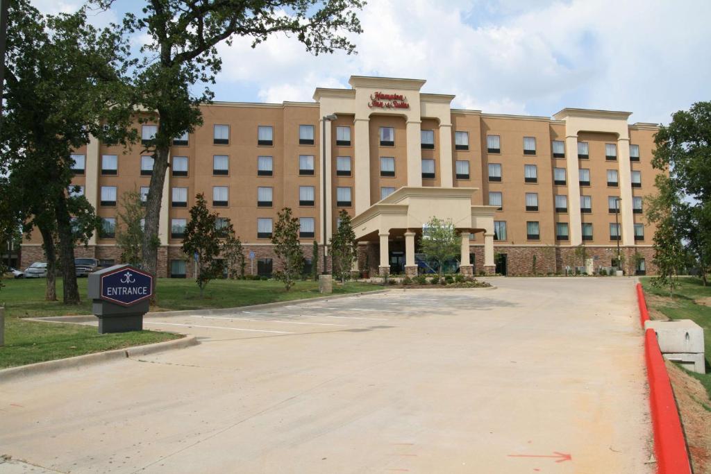 a large building with a sign in front of it at Hampton Inn & Suites Dallas-Arlington North-Entertainment District in Arlington