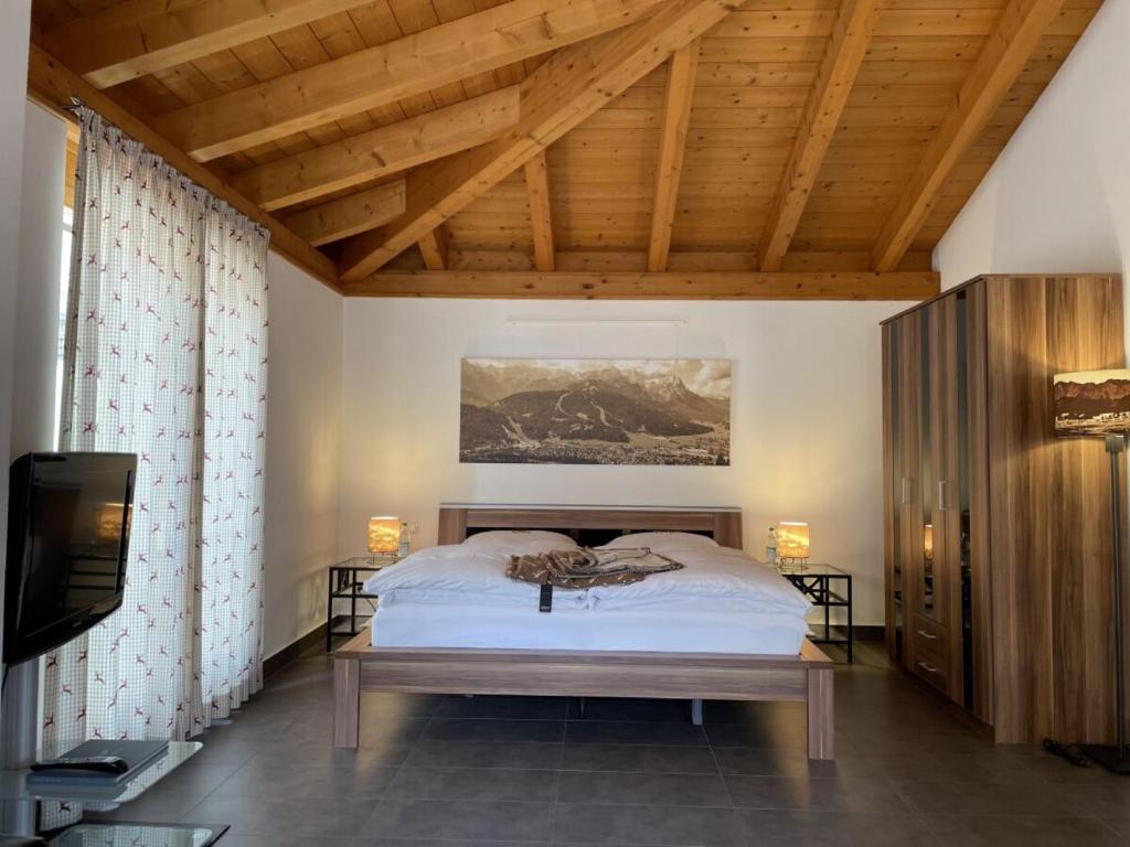 - une chambre avec un lit et un plafond en bois dans l'établissement Ferienwohnung Max 1, à Garmisch-Partenkirchen