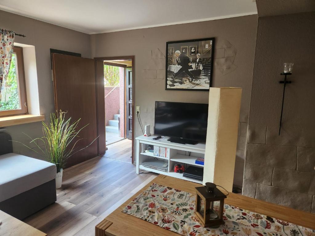 ein Wohnzimmer mit einem Flachbild-TV an der Wand in der Unterkunft Ferienwohnung Salut in Saarbrücken