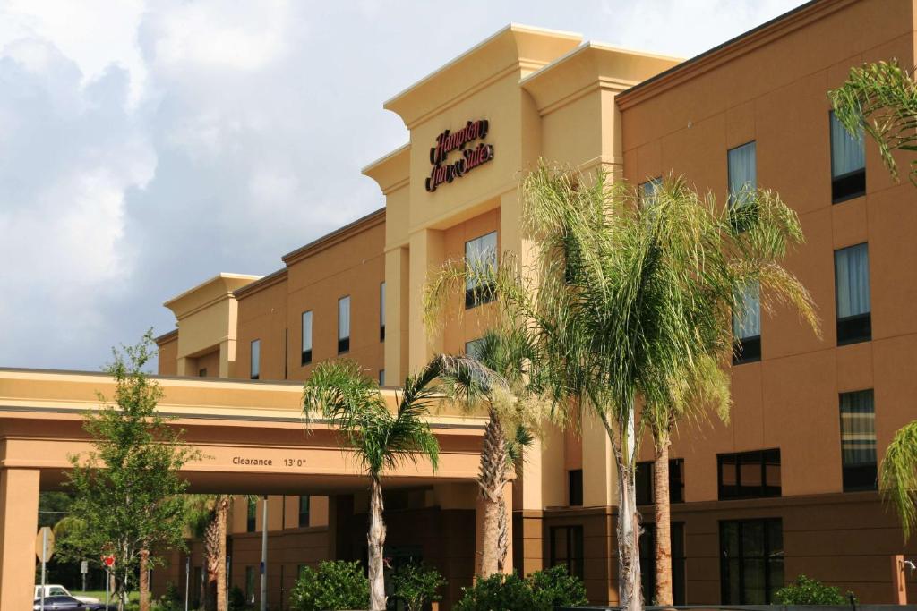 a building with palm trees in front of it at Hampton Inn & Suites Ocala - Belleview in Marion Oaks