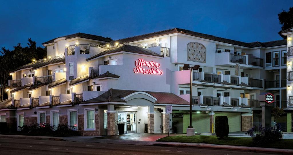 un gran edificio blanco con un letrero de neón. en Hampton Inn & Suites Hermosa Beach en Hermosa Beach