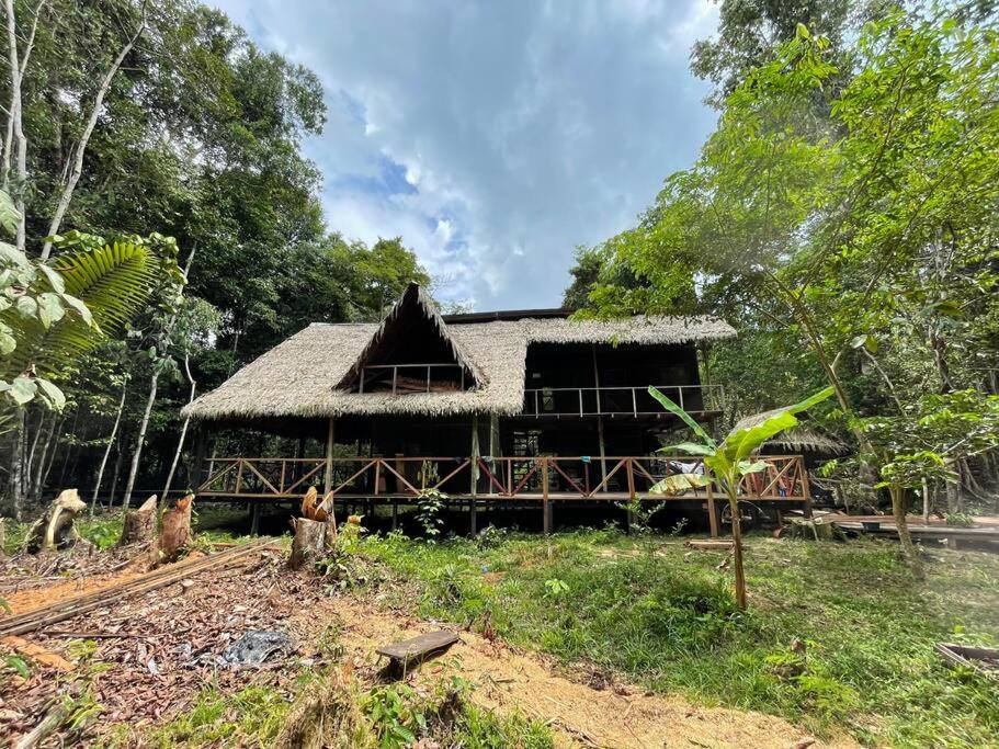 a large house with a thatched roof at Stay at the river house in Iquitos