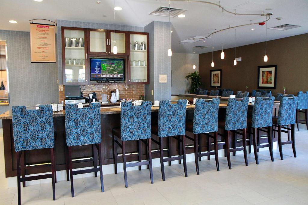 a bar in a restaurant with blue chairs at Hilton Garden Inn Midtown Tulsa in Tulsa