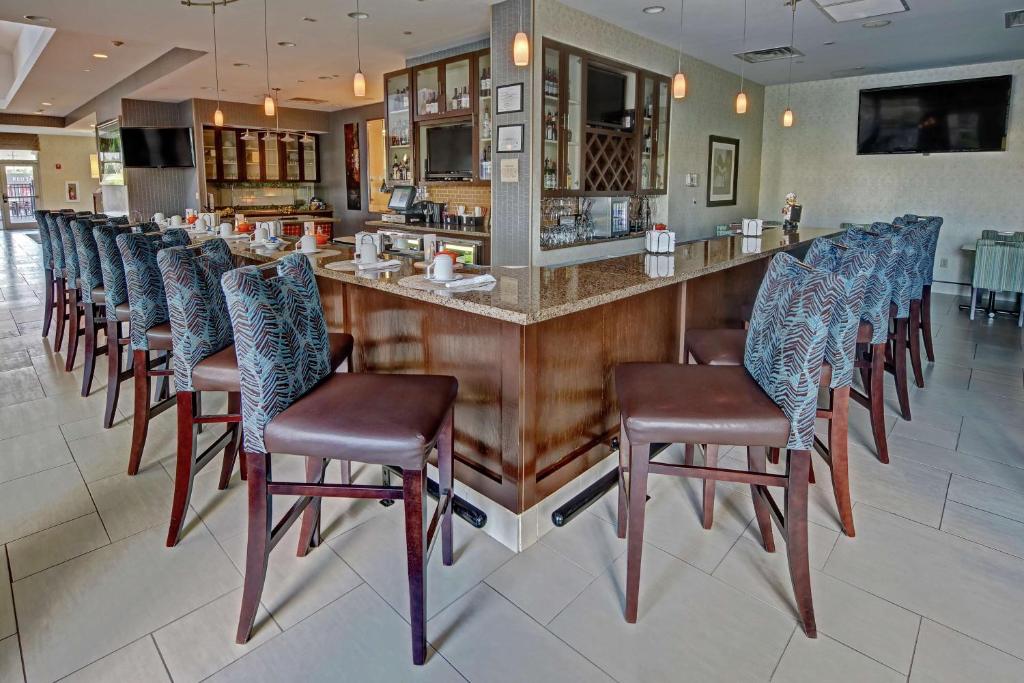 a bar with a row of chairs at a restaurant at Hilton Garden Inn Midtown Tulsa in Tulsa