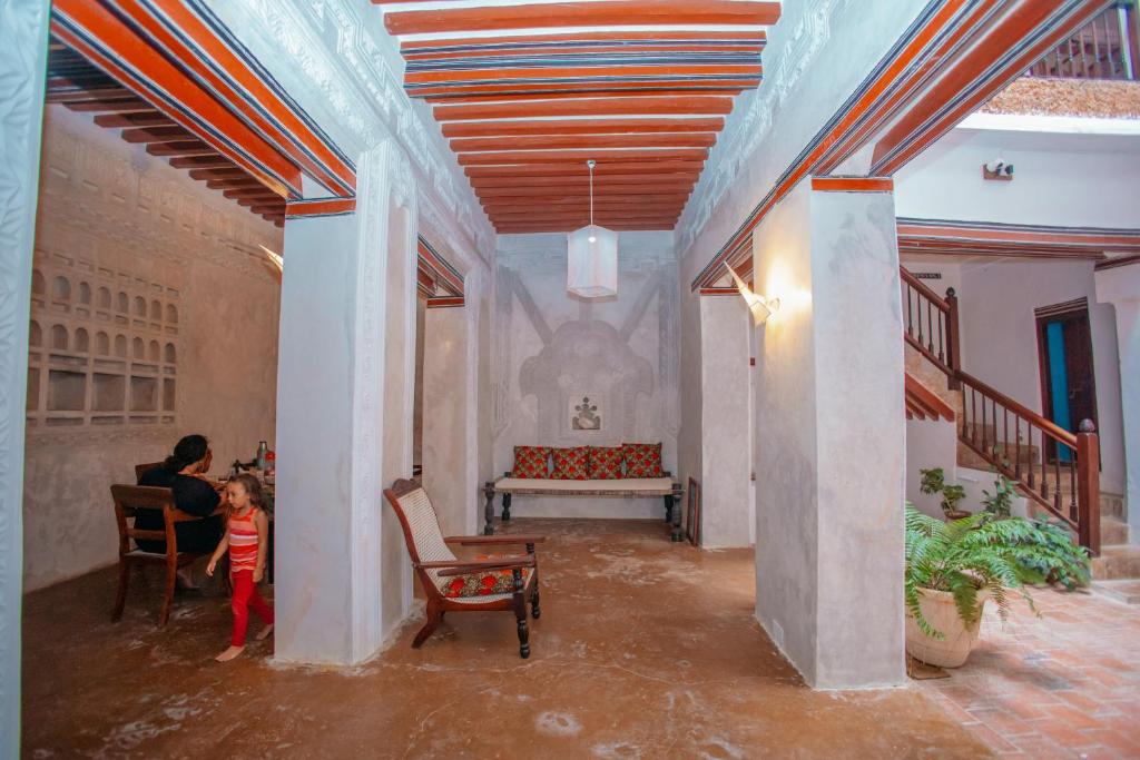 een vrouw en een kind die in een kamer staan bij Amu House in Lamu