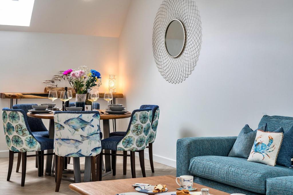 Una sala de estar con una mesa y un sofá azul. en Finest Retreats - Lobster House, en Newquay