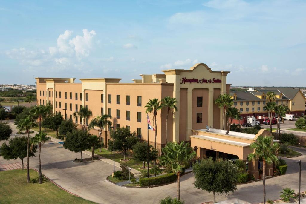 a large building with palm trees in front of it at Hampton Inn & Suites Pharr in Pharr