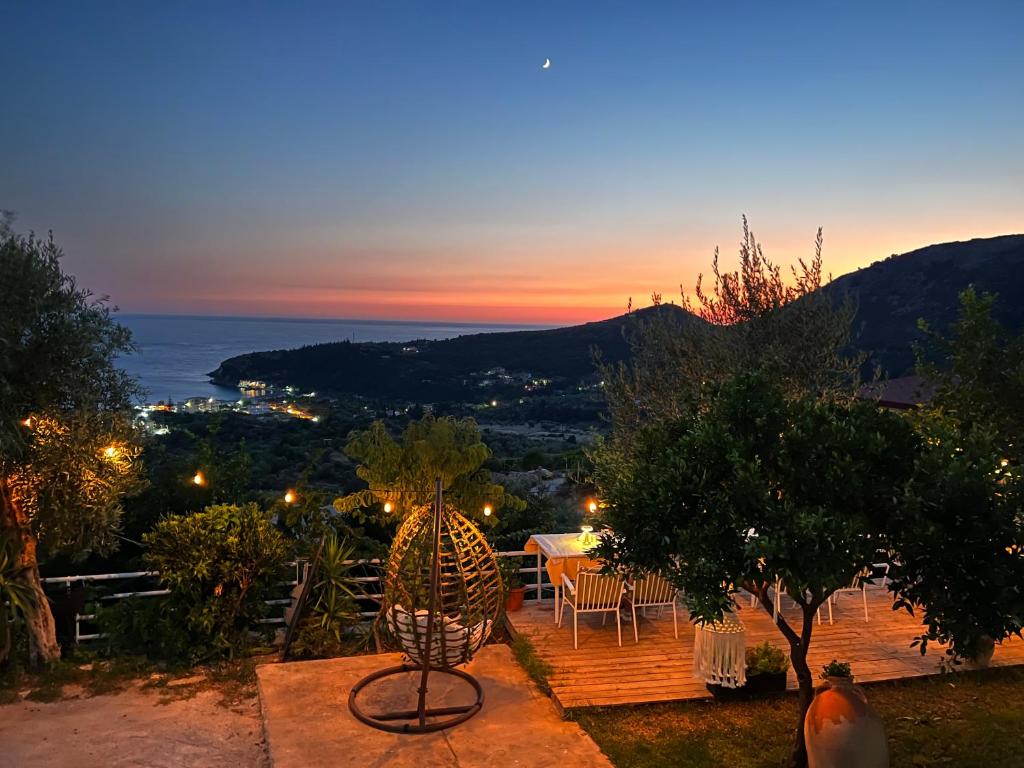 eine Terrasse mit einem Tisch, Stühlen und Meerblick in der Unterkunft Aphrodite's Garden in Himarë