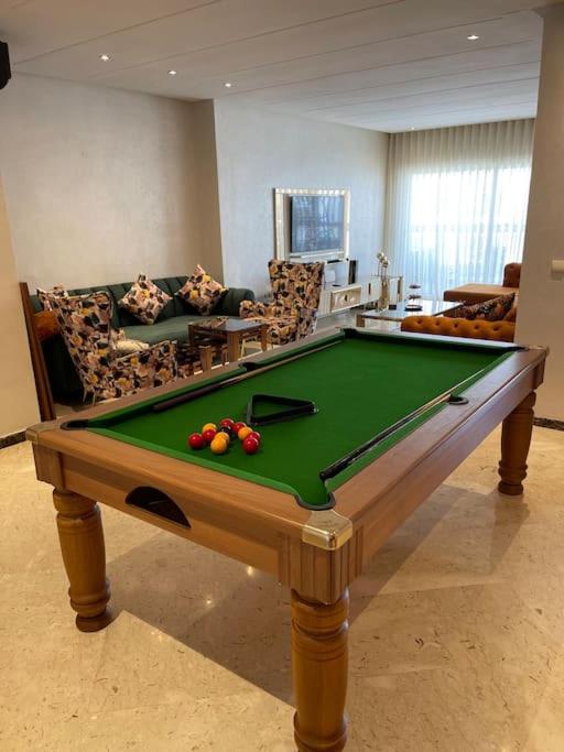 a living room with a pool table in front of a couch at Appartement de luxe à peninsula in Casablanca