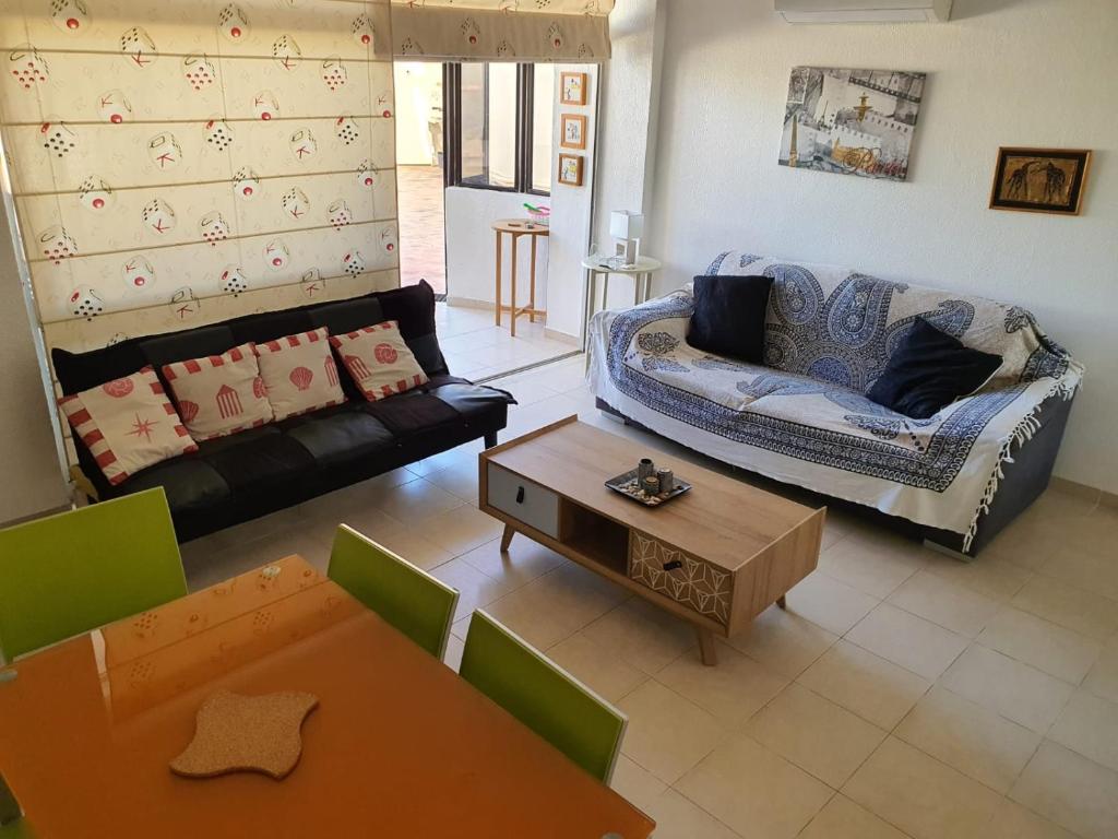 een woonkamer met een bank en een tafel bij Beira Mar Apartment in Portimão